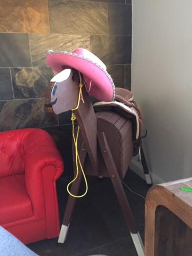 a fake cow with a hat on its head next to a chair at das Haus in Jois in Jois