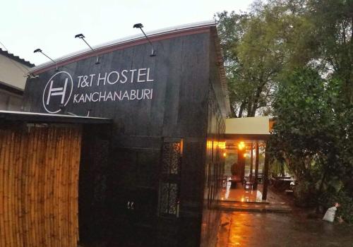 a restaurant with a sign on the side of a building at T & T Hostel Kanchanaburi in Kanchanaburi City