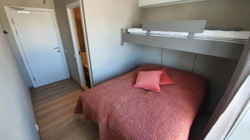a small bedroom with a pink pillow on a bed at Hovden Fjellstoge in Hovden