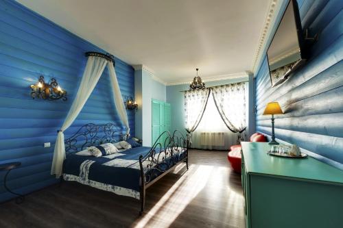 Dormitorio azul con cama y escritorio en Marton Skazka Hotel, en Rostov-on-Don
