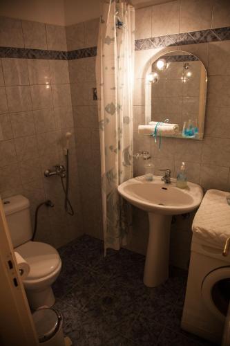 a bathroom with a sink and a toilet and a mirror at Greg's house Kefalonia in Argostoli