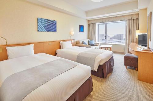 a hotel room with two beds and a television at Hotel Emion Tokyo Bay in Urayasu