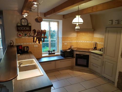 une cuisine avec un évier et un plan de travail dans l'établissement Gîte 4 km mer, 1 km centre ville, pour 8 pers, à Plestin-les-Grèves