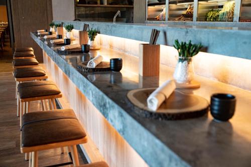a bar with a row of stools and a sink at 1 Hotel Haitang Bay, Sanya in Sanya