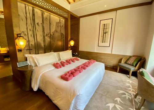 a bedroom with a bed with red roses on it at Banyan Tree Yangshuo in Yangshuo
