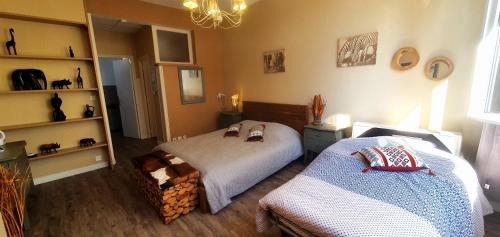 a bedroom with two beds and a book shelf at Cosy Er Lann Chambres d'Hôtes in Val Couesnon