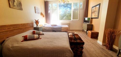 a hotel room with two beds and a window at Cosy Er Lann Chambres d'Hôtes in Val Couesnon