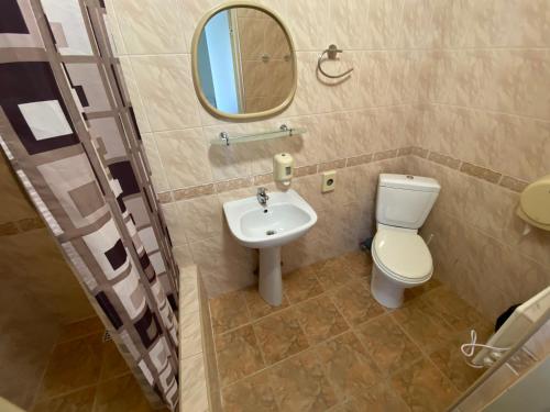 a bathroom with a toilet and a sink and a mirror at Dorell in Tallinn