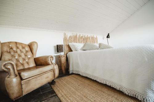 1 dormitorio con 1 cama y 1 silla en The ONE - Country House, en Grândola