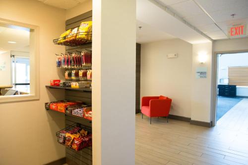 a waiting room with a red chair and a room with food at Holiday Inn Express Hotel & Suites Chanhassen by IHG in Chanhassen