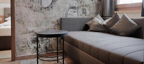 a couch with a side table next to a wall at Montana Hochfügen in Hochfugen