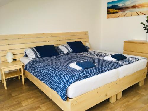 a bedroom with a bed with blue and white sheets at Apartmany a Ubytovani Mlynice Litovel in Litovel