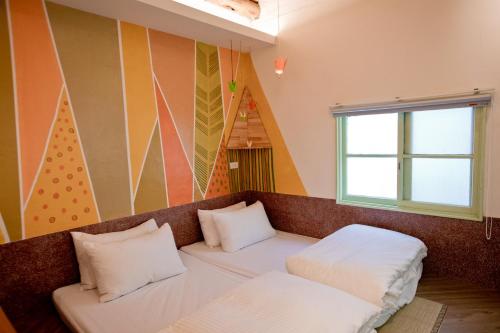a room with a bed with two pillows on it at My Way House 好巷一弄民宿 in Tainan