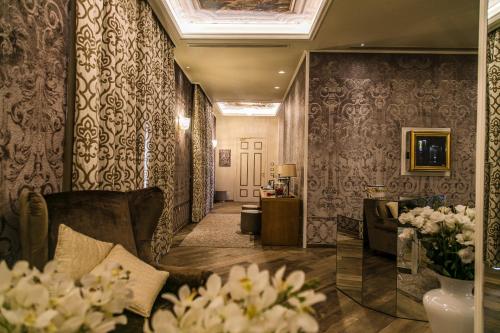 a living room with a couch and floral wallpaper at Hotel Villa Pascucci in Durrës