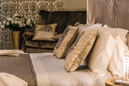 a bedroom with a bed with pillows and a couch at Hotel Villa Pascucci in Durrës