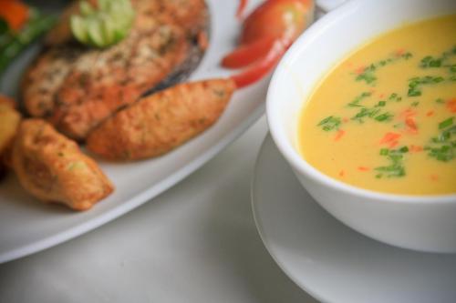 a plate with a bowl of soup and a plate of food at Lavendish Okrin Hotel in Kataragama