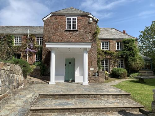 an exterior view of a brick house with a green door at Boscundle Manor in St Austell
