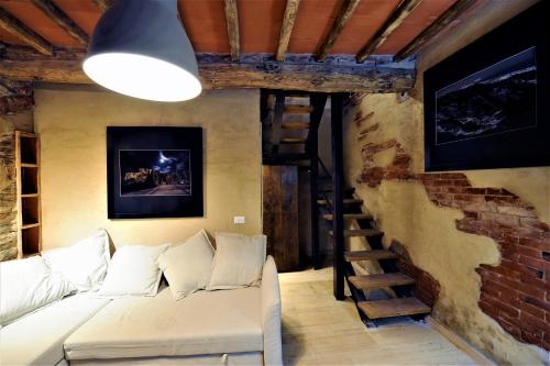 a living room with a couch and a brick wall at Incantevole casa sul fiume, Relax e Natura ai piedi della Alpi Apuane in Massa