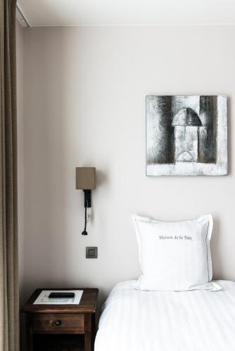a bedroom with a bed and a table with a lamp at Maison de la Paix in Poperinge