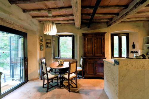 a kitchen with a table and chairs in a room at Incantevole casa sul fiume, Relax e Natura ai piedi della Alpi Apuane in Massa