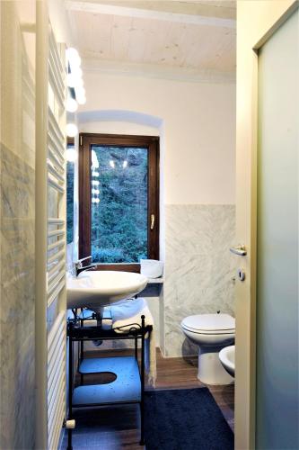 a bathroom with two toilets and a sink at Incantevole casa sul fiume, Relax e Natura ai piedi della Alpi Apuane in Massa