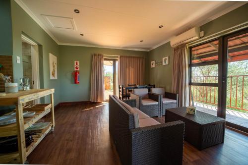 a living room with a couch and chairs and a table at Red Sands Country Lodge in Kuruman