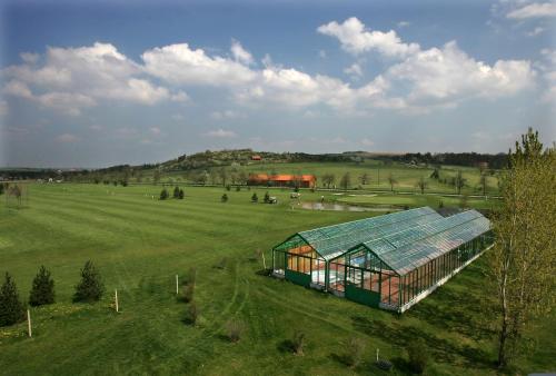 a large green greenhouse in a field of grass at Darovanský Dvůr - Wellness & Golf Hotel in Břasy
