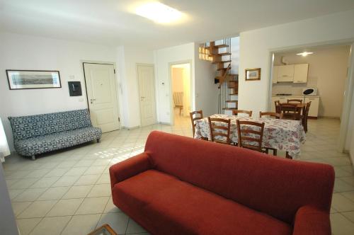 a living room with a red couch and a table at I Pungenti in Castiglioncello