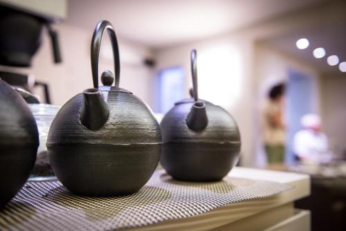 three black vases sitting on top of a table at Maison de la Paix in Poperinge