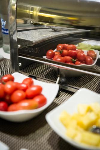 a table with plates of tomatoes in front of a toaster at Maison de la Paix in Poperinge