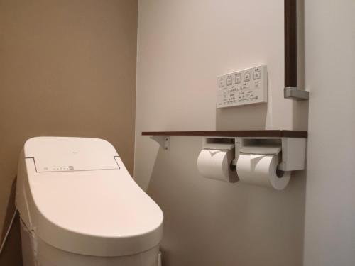 a small bathroom with a toilet and toilet paper dispenser at 4S STAY Awaikeda Honmachi Street in Miyoshi