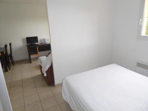 a bedroom with a bed and a desk with a computer at Résid'Artel Cadarache - ITER in Saint-Paul-lez-Durance