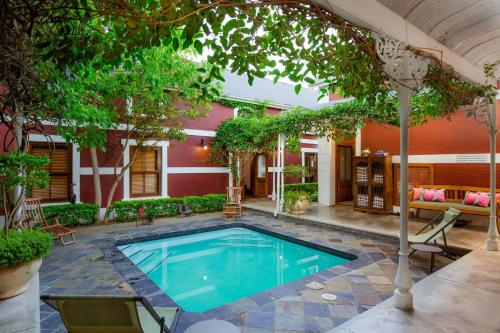 a swimming pool in the courtyard of a house at Roosenwijn Guesthouse in Stellenbosch
