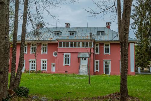a large red house with a gray roof at Apartments Mirković in Cetinje