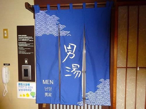 a blue curtain with asian writing on a door at Dormy Inn Kagoshima in Kagoshima