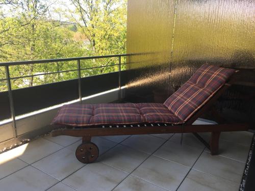 a porch swing with a pillow on a balcony at Appartementresidenz am Kurpark - Ferienwohnungen mit Pool & Sauna & Garage in Bad Salzuflen