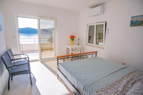 a bedroom with a bed and a view of the ocean at 3 Bedroom Beach House with private sea access in Slano