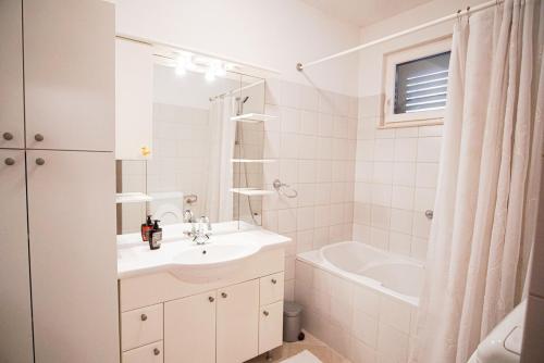 a bathroom with a sink and a tub and a toilet at 3 Bedroom Beach House with private sea access in Slano