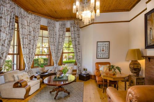 a living room filled with furniture and a chandelier at Roosenwijn Guesthouse in Stellenbosch