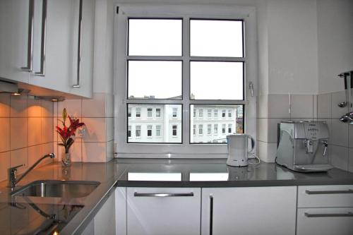 a kitchen with a sink and a window at Sylter Apartments Wilhelmstrasse in Westerland