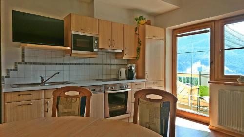 a kitchen with a table and a large window at Apartment Prossegger in Neukirchen am Großvenediger