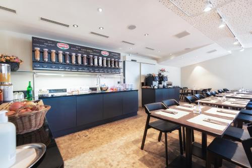 un ristorante con tavoli, sedie e bancone di Hotel one66 (free parking garage) a St. Gallen