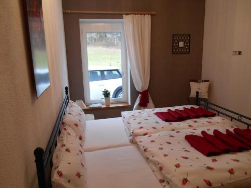 شقة كارب ديم في كرامساش: غرفة نوم بسريرين ومخدات حمراء ونافذة