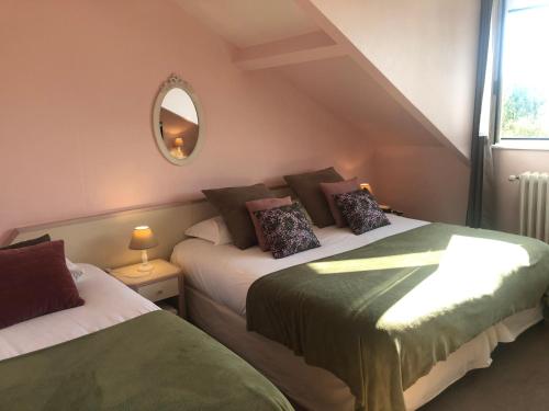 a bedroom with two beds and a mirror at Hotel de L'Oise in Saint-Leu-dʼEsserent