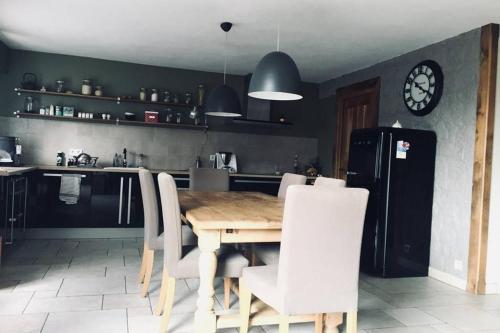 a kitchen with a wooden table and white chairs at Numéro 9 in Légna