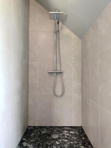 une douche avec pommeau de douche dans une salle de bain dans l'établissement Coeur du Finistère, à Pleyben