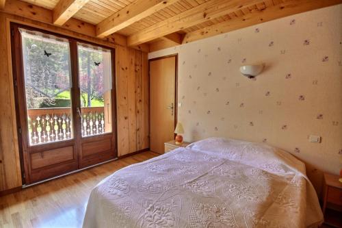 a bedroom with a bed and a large window at GRAND APPARTEMENT - WIFI -SAINT JEAN D'AULPS - 12 Personnes - HIRONDELLE in Saint-Jean-d'Aulps