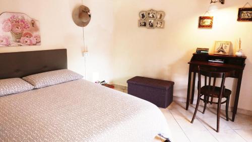 um quarto com uma cama, uma mesa e um banco em Oneiro Bed and Relax em Benevento