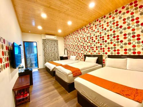 una habitación de hotel con 2 camas y una pared con un mural en Mini Home B&B, en Kangle