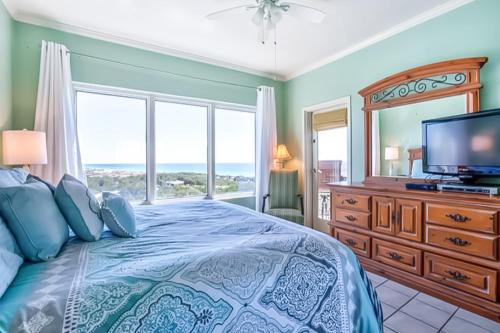 a bedroom with a bed with a television and a window at TOPS'L Summit in Destin